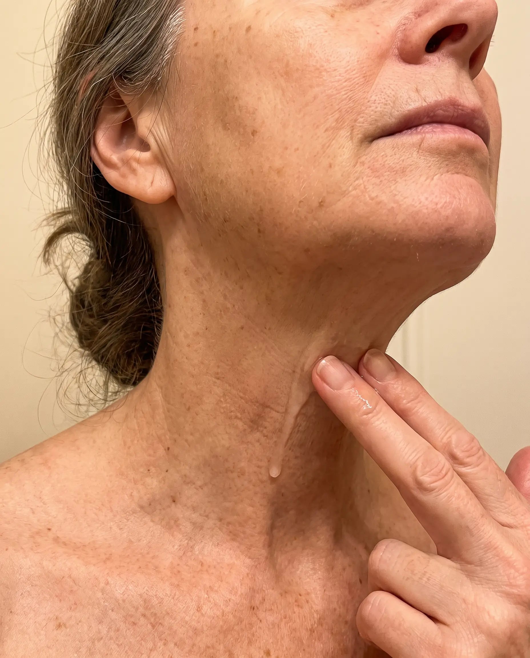 Applying serum downward along the side of the neck